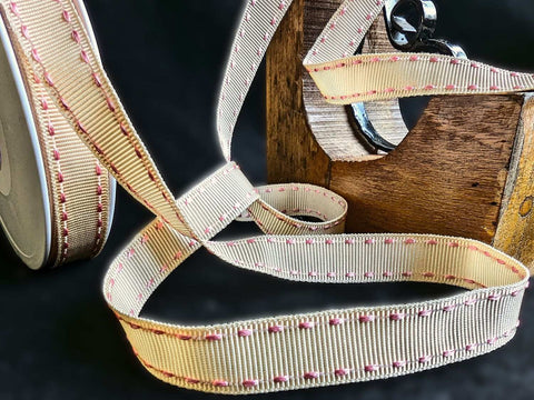 Cream grosgrain ribbon with pink stitch edges, polyester material