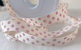 16mm width natural cream polyester grosgrain ribbon with pink polka dots. made by Berisfords Ribbons in the UK.