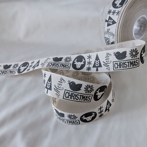 Berisfords premium quality pale beige rustic cotton look polyester taffeta ribbon with a graphite Christmas motif print. 25mm wide. Cut to length at Ribbonmoon Haberdashery Shop.