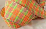 A 40mm wide plaid tartan ribbon with an oatmeal-colored base, featuring vibrant neon stripes in orange, green, yellow, and pink.
