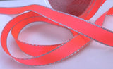fluorescent pink satin ribbon with a silver metallic edge.