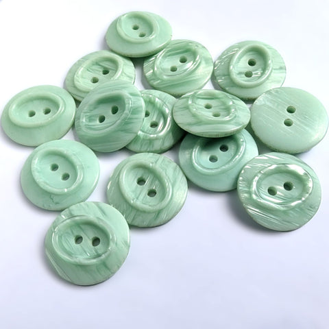 23mm pale mint green satin sheen polyester 2 Hole Button with pearlised shimmery elements and an oval centre.