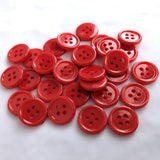 Red 15mm acrylic 4 hole buttons with a gloss finish and a raised ringed rim.