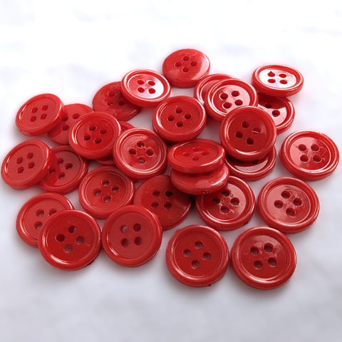Red 15mm acrylic 4 hole buttons with a gloss finish and a raised ringed rim.
