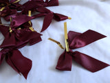 30 maroon satin ribbon bows with a centre wire for attachment. 7cm x 6cm . Clearance sale, less than 9p each. Ribbonmoon UK craft & sewing online.