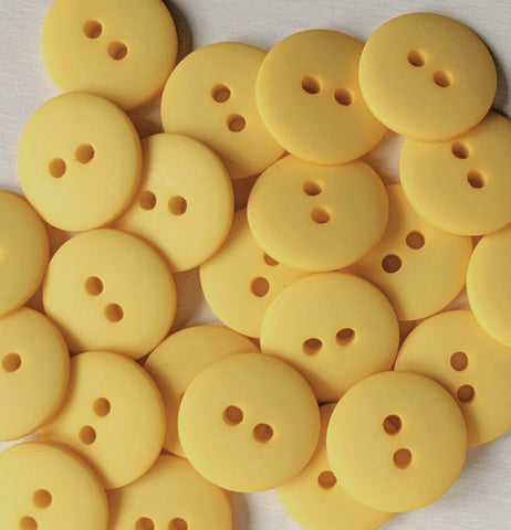 Yellow buttons with two holes on a light background