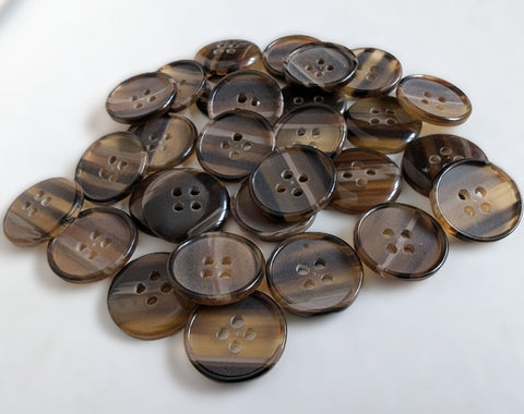 50 buttons for £2.00.
19 mm polyester four‑hole button with a matte, lightly translucent centre, a raised glossy rim, and a domed high‑gloss back.