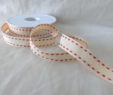 Length of 16mm cream grosgrain ribbon with red satin stitched edges, displayed flat to show colour and finish