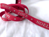 Berisfords red Christmas taffeta ribbon with Joy Peace Love Noel print, 15mm wide. ⠋