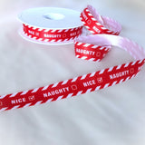 Berisfords 16mm Red and white Naughty or Nice printed Christmas satin ribbon on a spool.