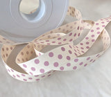 16mm width natural cream polyester grosgrain ribbon with pink polka dots. made by Berisfords Ribbons in the UK.