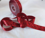 Deep red 25mm satin ribbon with a subtle baroque leafy print. Ribbonmoon online shop, buy rare unusual ribbons sold by the metre, cut to length.