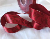 Deep red 25mm satin ribbon with a subtle baroque leafy print. Ribbonmoon online shop, buy rare unusual ribbons sold by the metre, cut to length.