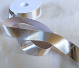 25mm wide silver grey printed satin ribbon. Metallic silver and gold geometric cross hatch design by Berisfords Ribbons K. Buy online per metre and cut to length. Ribbonmoon Haberdashery Shop.