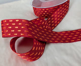 Red taffeta ribbon with orange parallel stitch detail, shown partially unrolled from the spool on a white background