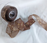 Berisfords Ribbons Dark brown super sheer ribbon with a metallic gold Christmas star print. 27mm wide. Buy online per metre & cut to length with full roll discounts.