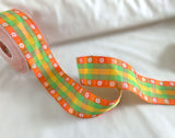 Close‑up of orange and green daisy jacquard gingham ribbon showing woven detail.