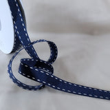 15mm navy polyester grosgrain ribbon with white satin stitch borders. UK manufactured by Berisfords Ribbons. buy online per metre with discount for full 15 metre reels.