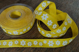 Yellow cotton ribbon tape with a white flower pattern. 20mm wide availab;e to buy per metre